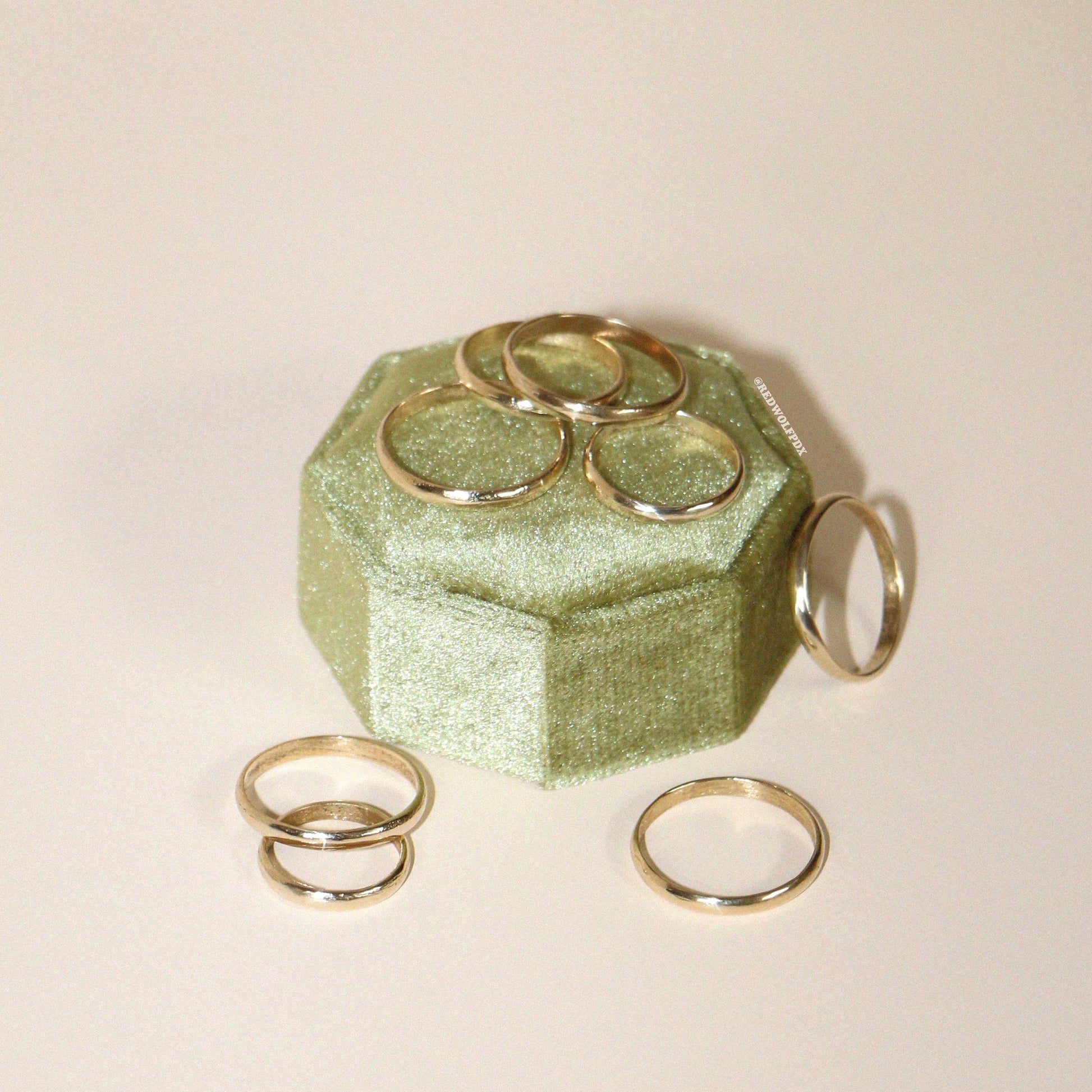 A collection of rings displayed on a green textured surface