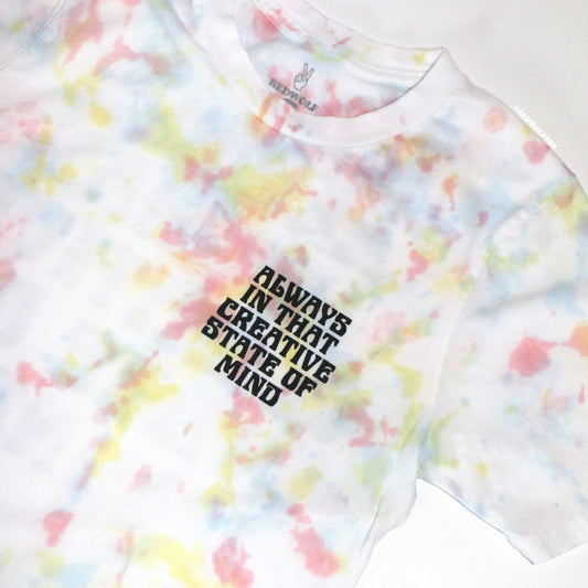 Tie-dye t-shirt with text 'Always in that creative state of mind' on a white background