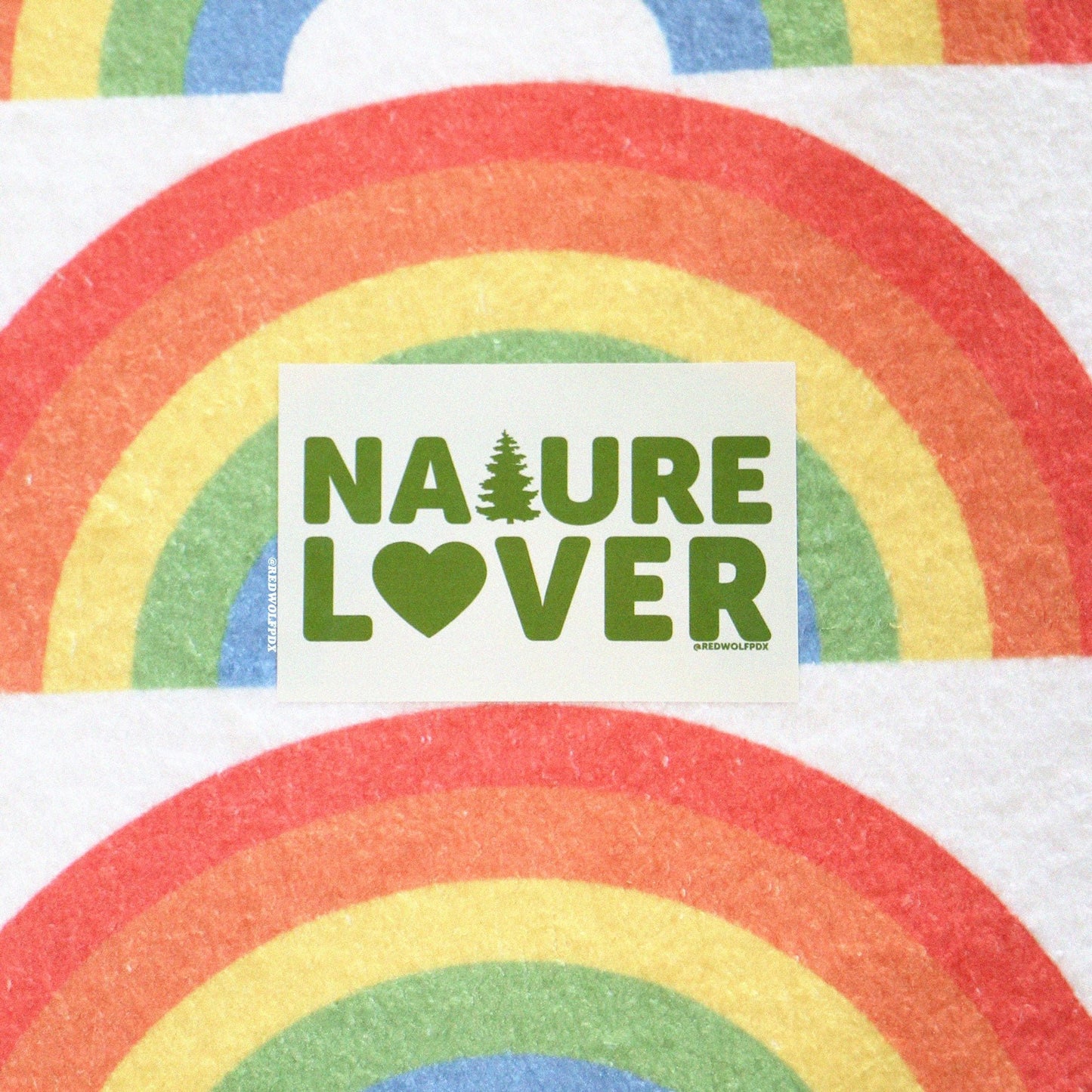 Rectangle beige sticker with text 'NATURE LOVER' in green ink against retro rainbow backdrop
