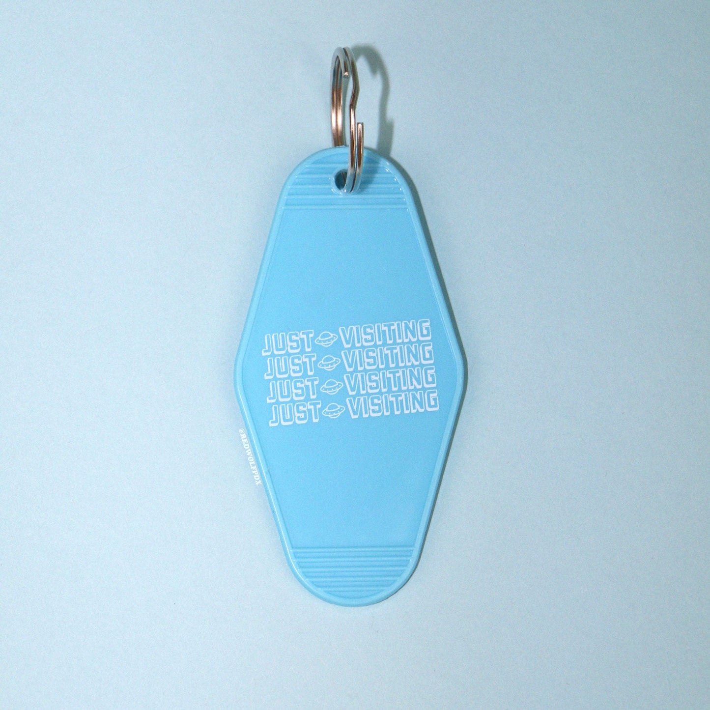 Baby blue retro motel style keychain on a blue background
