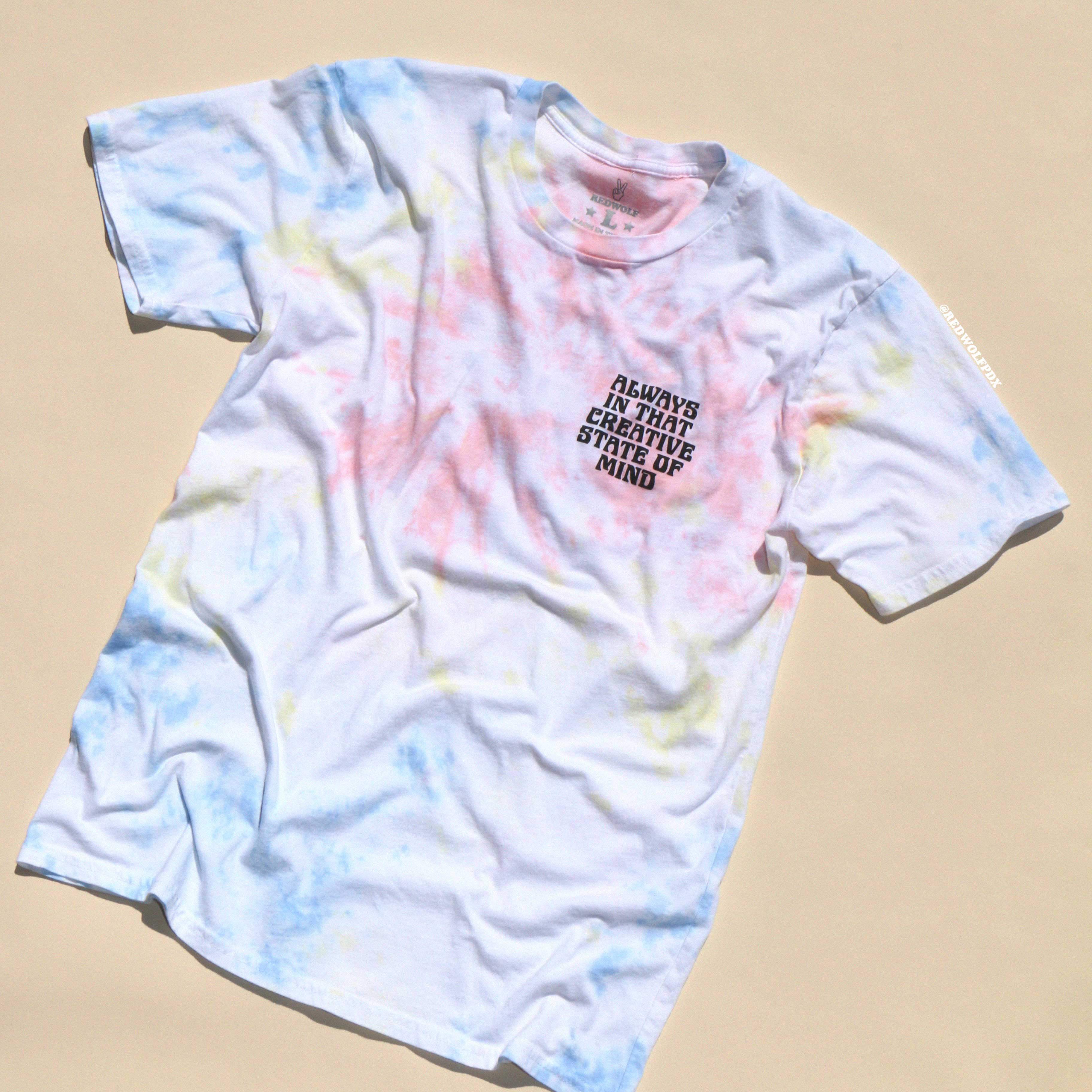 A tie-dye t-shirt with a text design on the front, featuring a colorful swirl pattern on a white background.