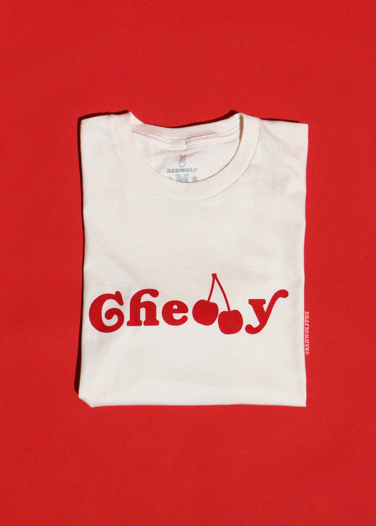 Folded white t-shirt with red text and cherry graphic on a red background