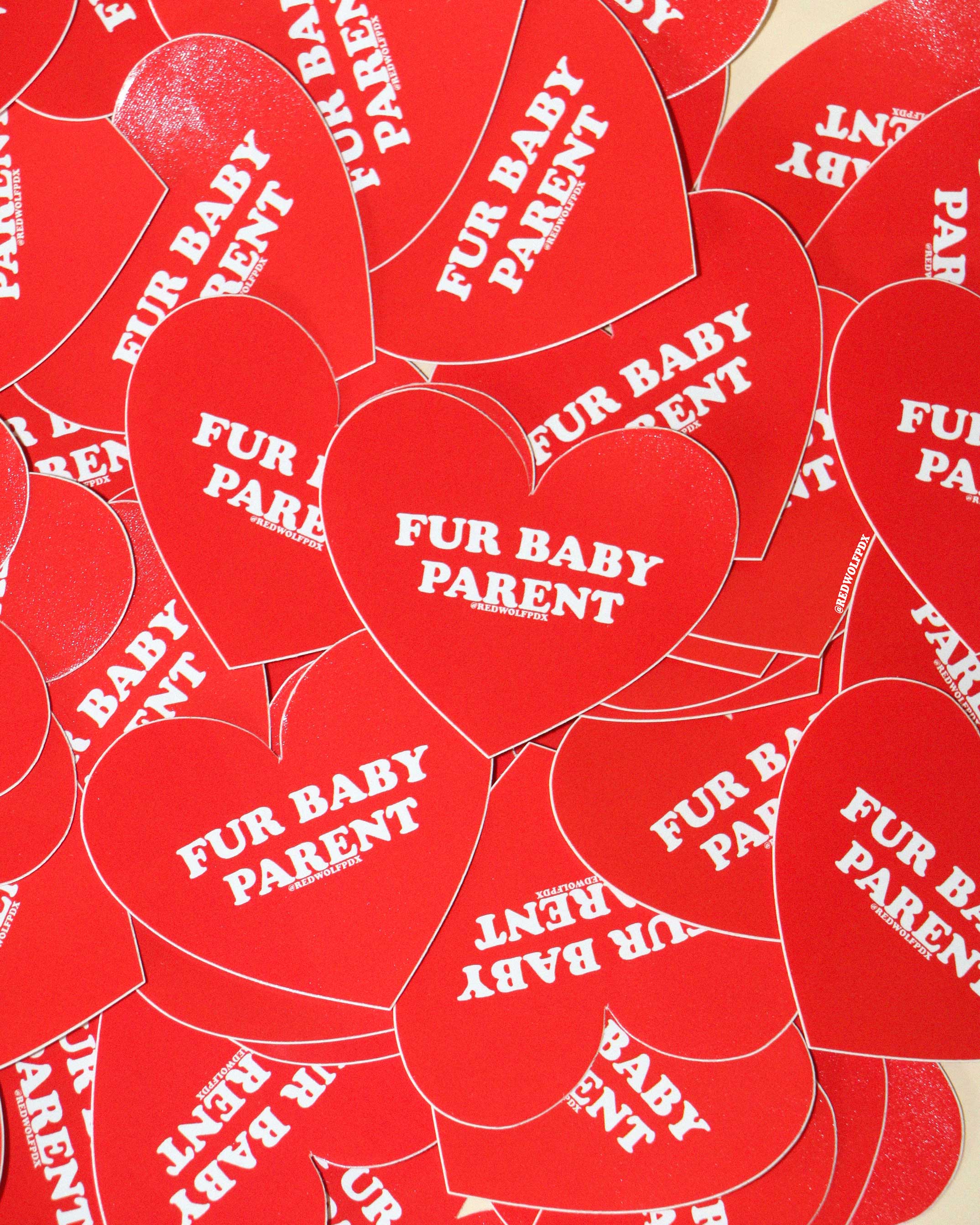 a pile of red heart shaped stickers with text 'FUR BABY PARENT' on beige background