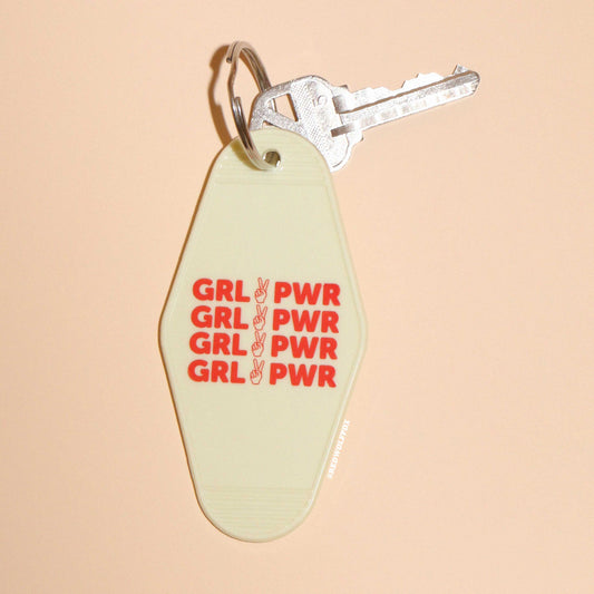 Keychain with 'GRL PWR' text on a beige background