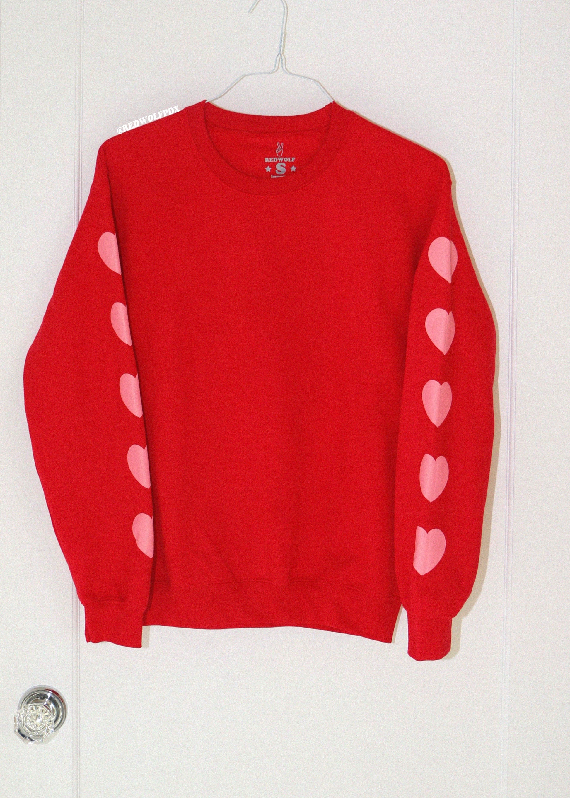 Red sweater with pink heart designs on a white background