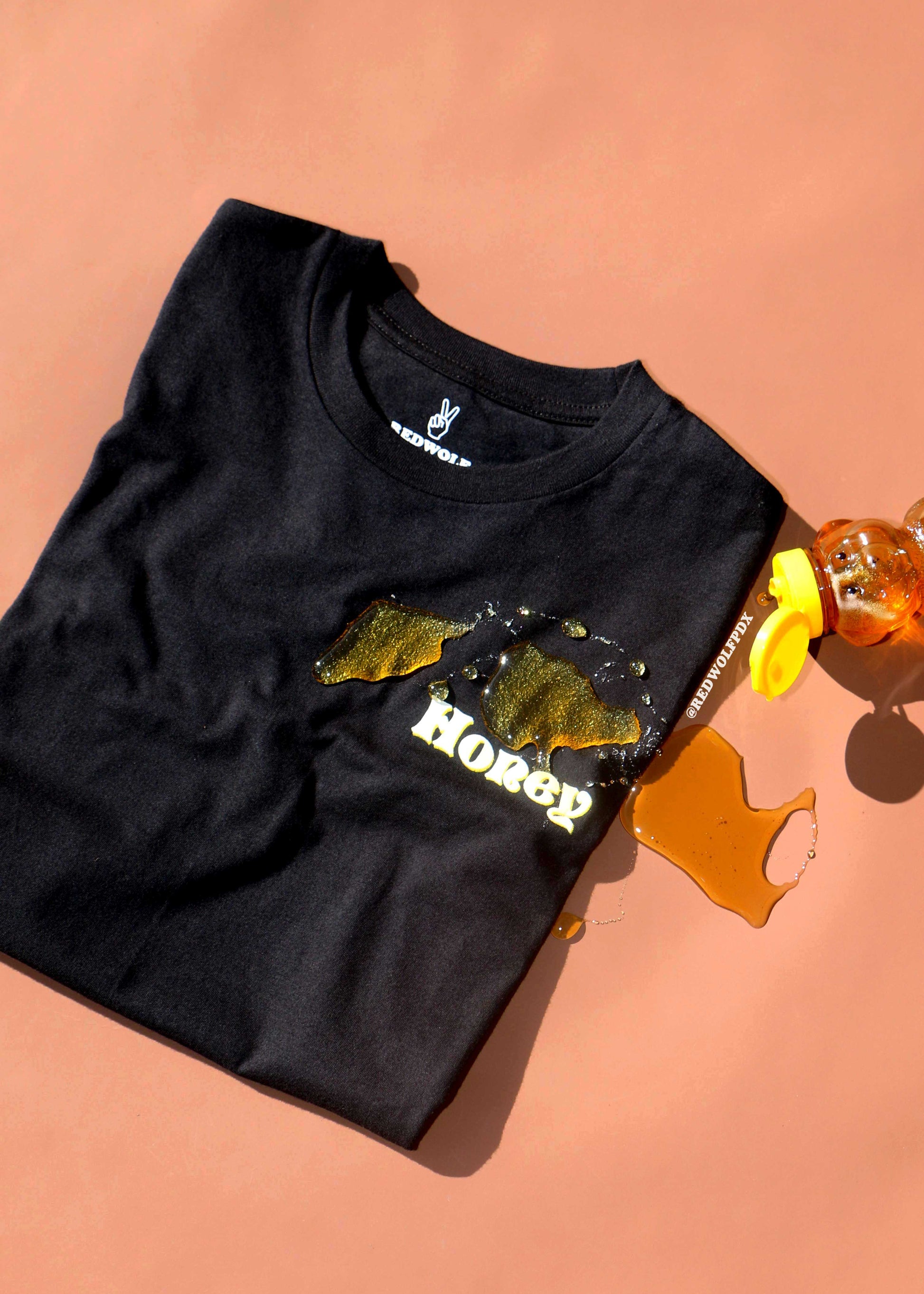 Black t-shirt with graphic design on a peach background
