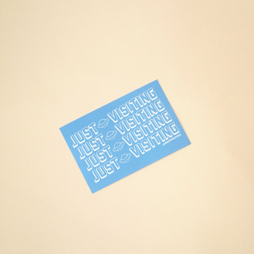 Blue sticker with 'JUST VISITING' text on a beige background