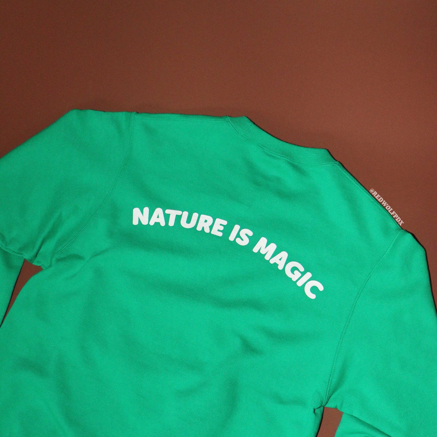 Green shirt with 'NATURE IS MAGIC' text on a brown background