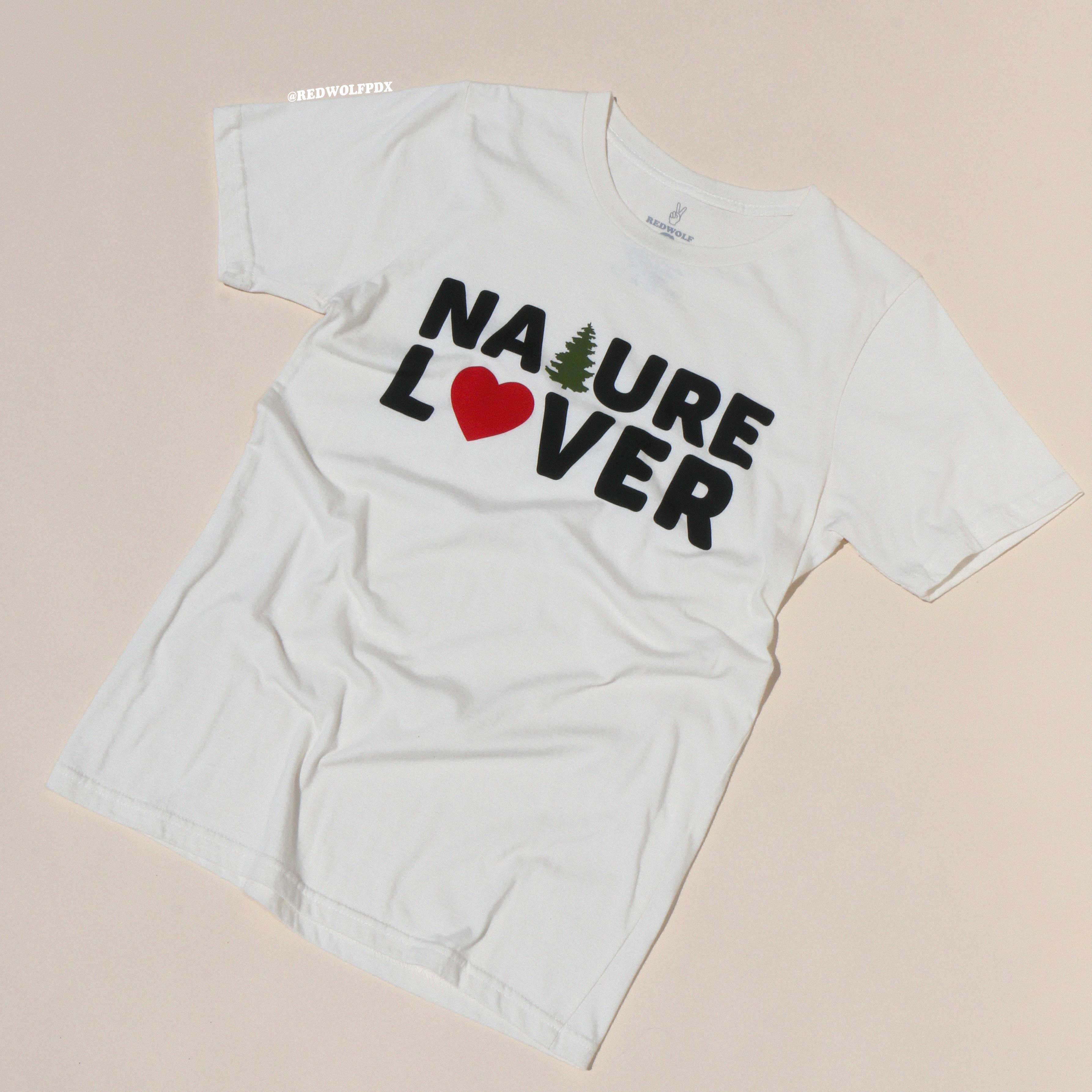 White t-shirt with 'Nature Lover' text and heart design on a beige background