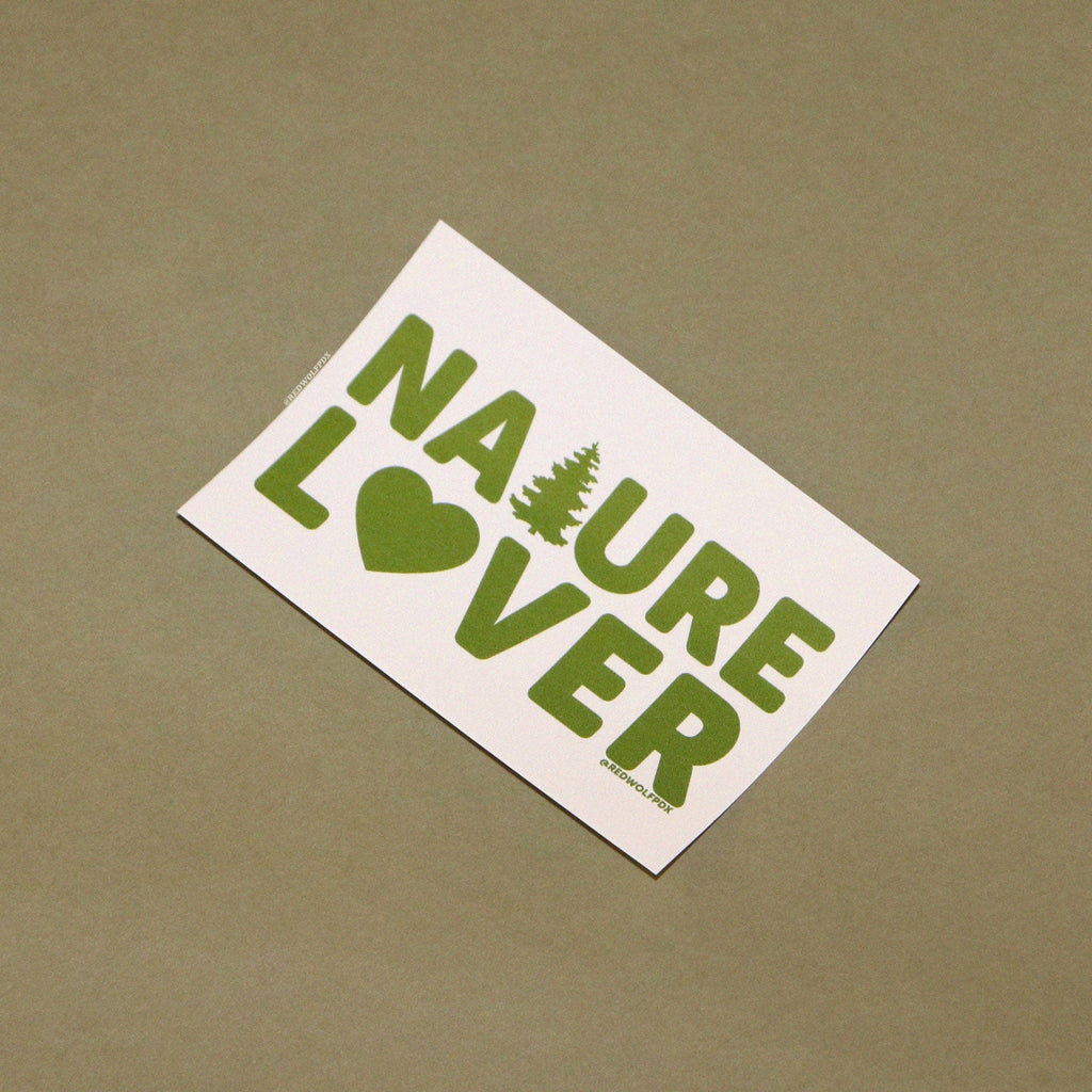 Rectangle beige sticker with text 'NATURE LOVER' in green ink against green backdrop
