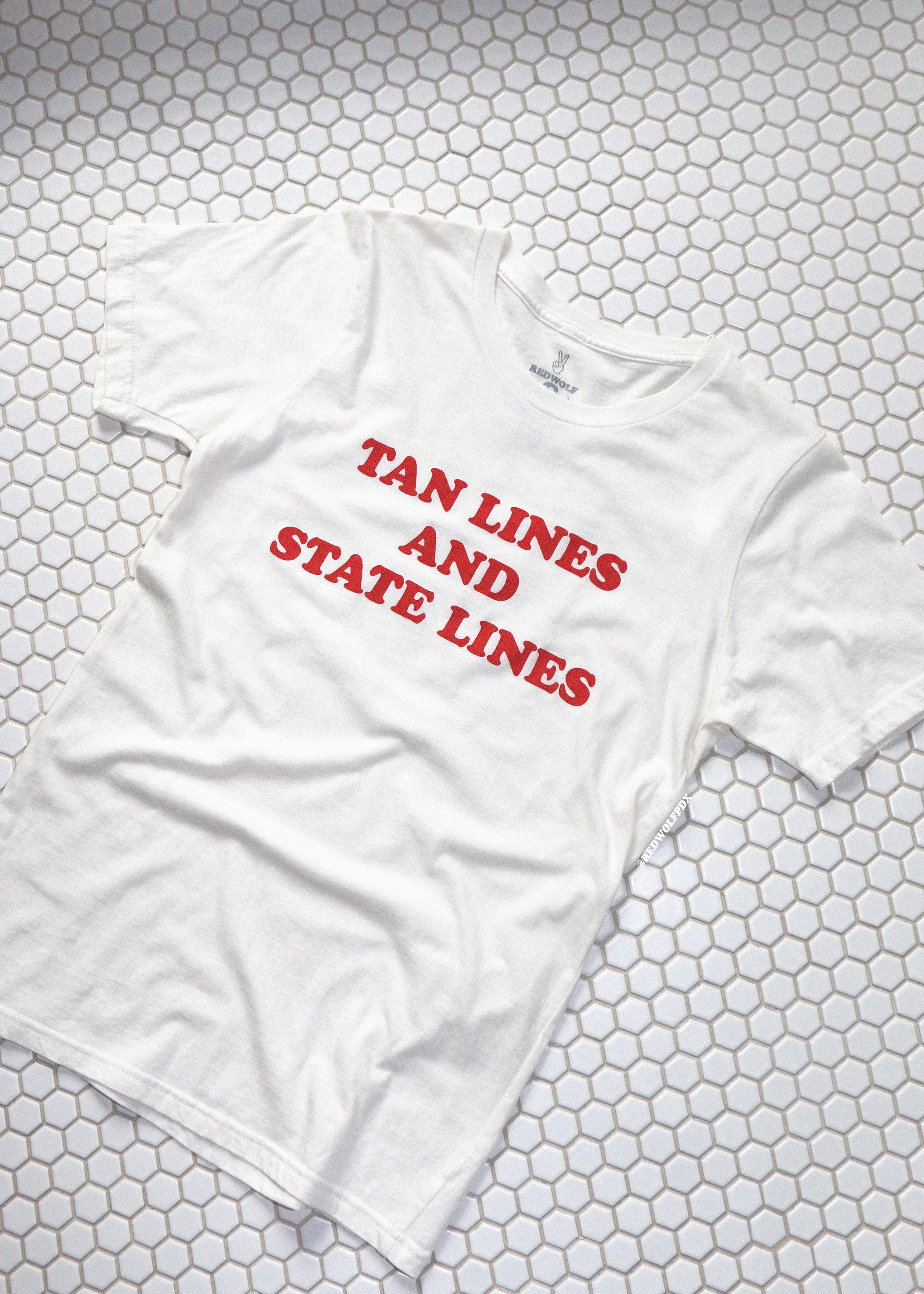 White t-shirt with red text 'TAN LINES AND STATE LINES' on a hexagonal tile background