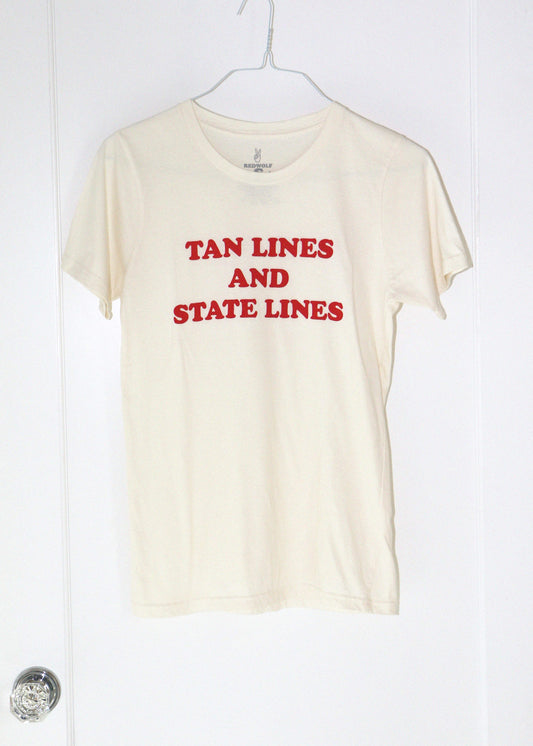 Beige t-shirt with red text 'TAN LINES AND STATE LINES' on a white hanger against a white background.