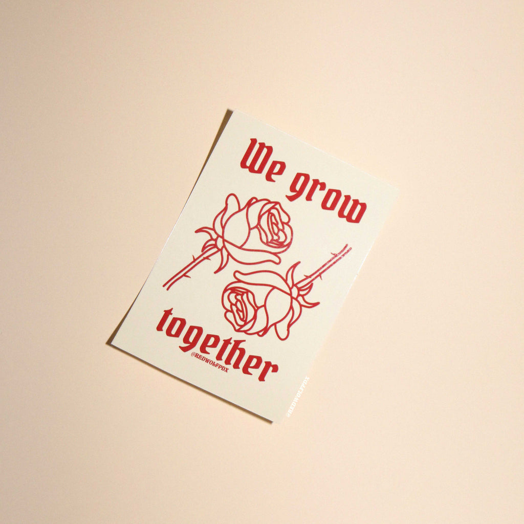 beige sticker with text 'We grow together  in gothic font with 2 red roses illustration graphic sticker on beige 
backdrop