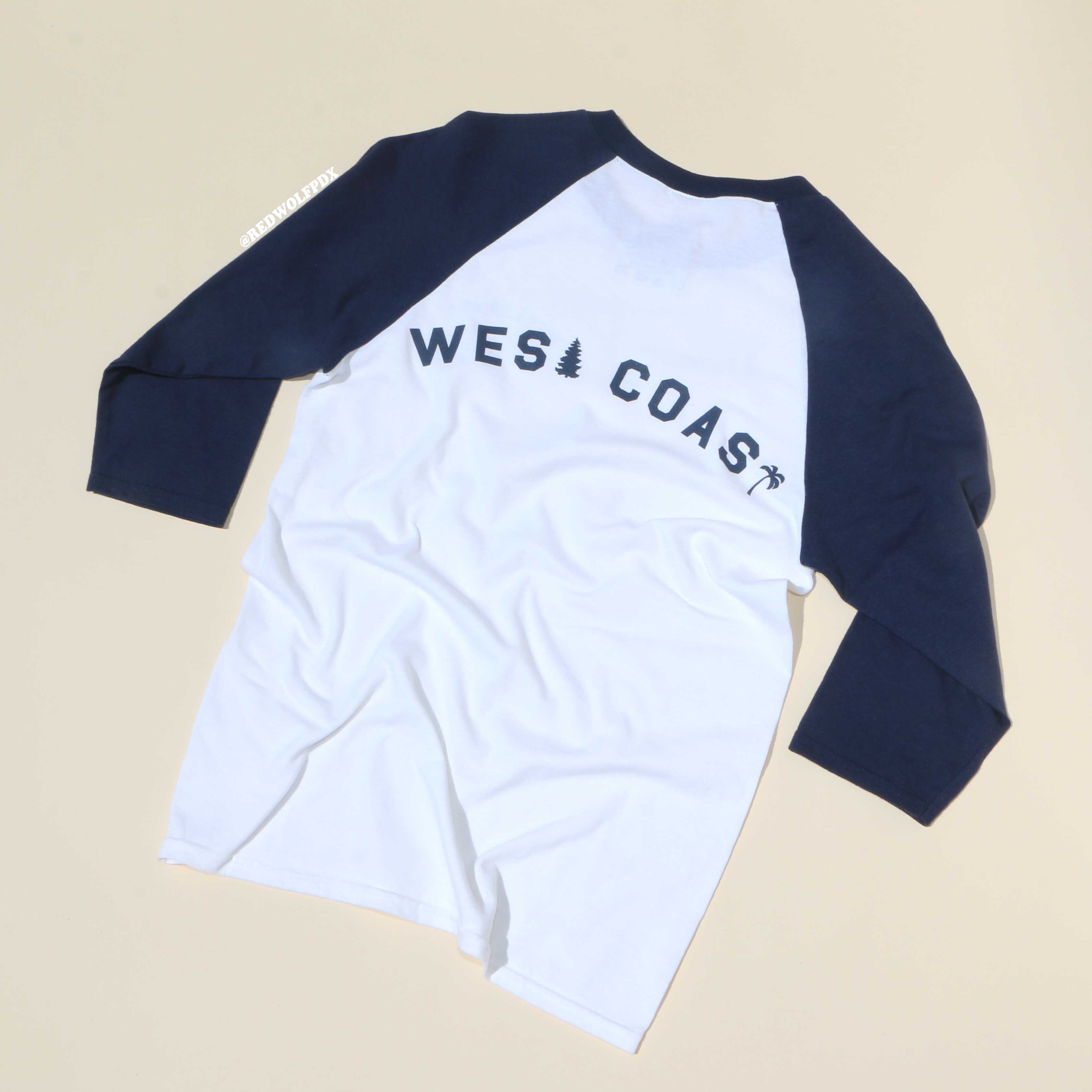 White and navy long-sleeve shirt with 'WEST COAST' text on a beige background