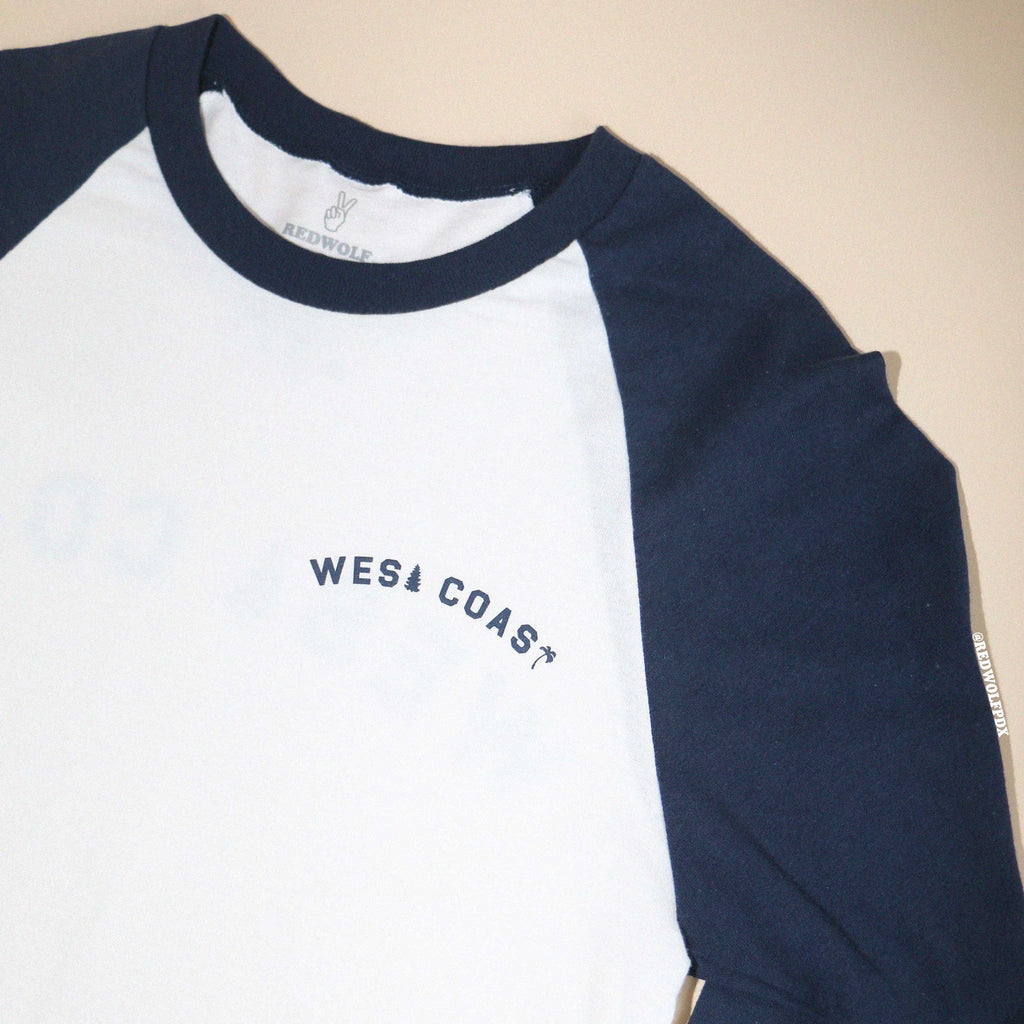 White and navy long-sleeve shirt with 'WEST COAST' text on a beige background