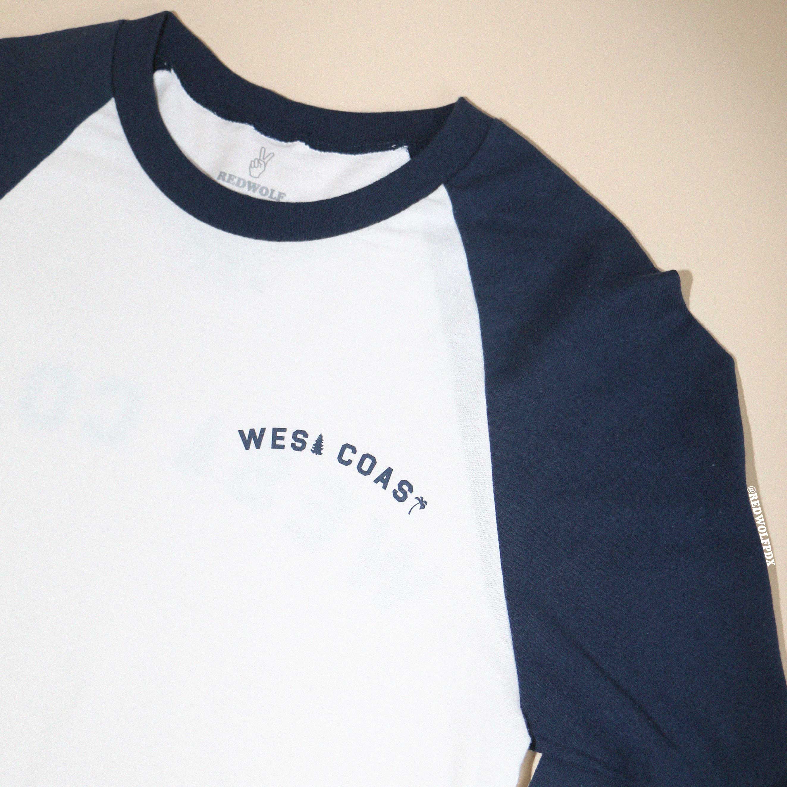 White and navy long-sleeve shirt with 'WEST COAST' text on a beige background