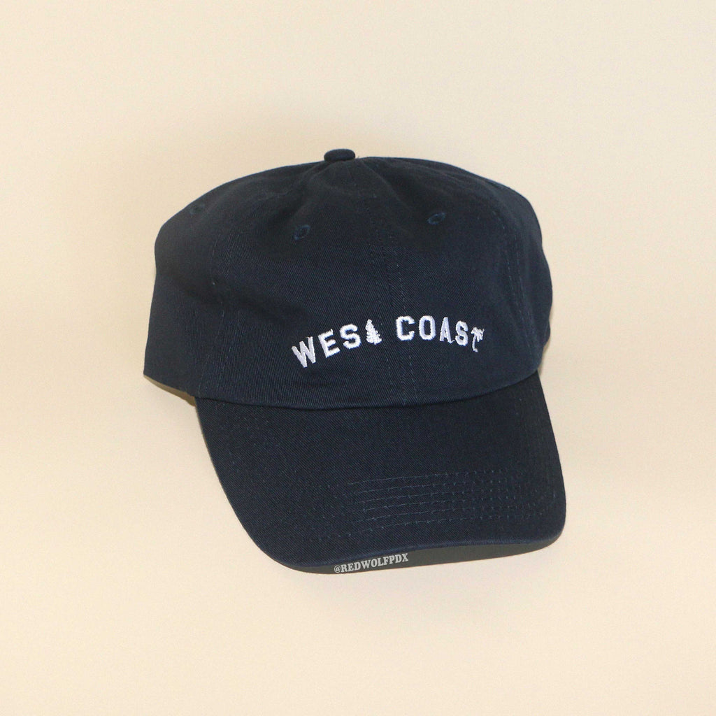 Navy blue baseball cap with text 'WEST COAST' embroidered across front