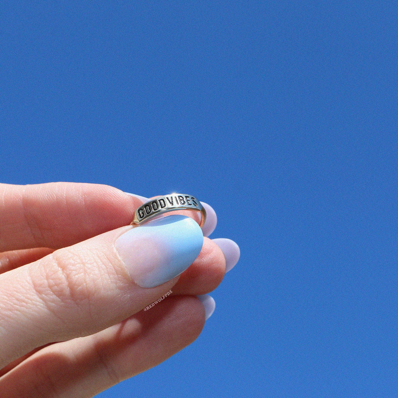 etched good vibes ring being held to the sky
