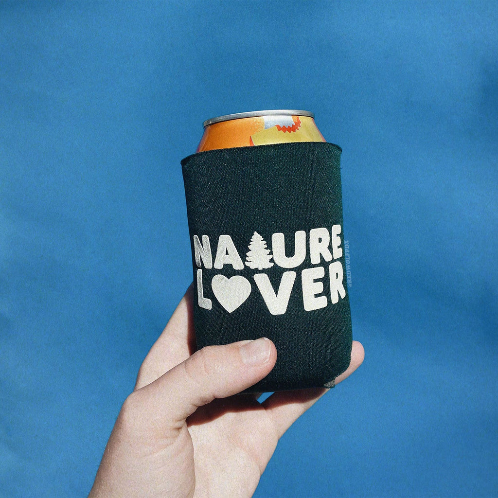 Forest green neoprene drink sleeve with white text 'NATURE LOVER' holding a cold 12 oz can beverage in hand against retro blue backdrop