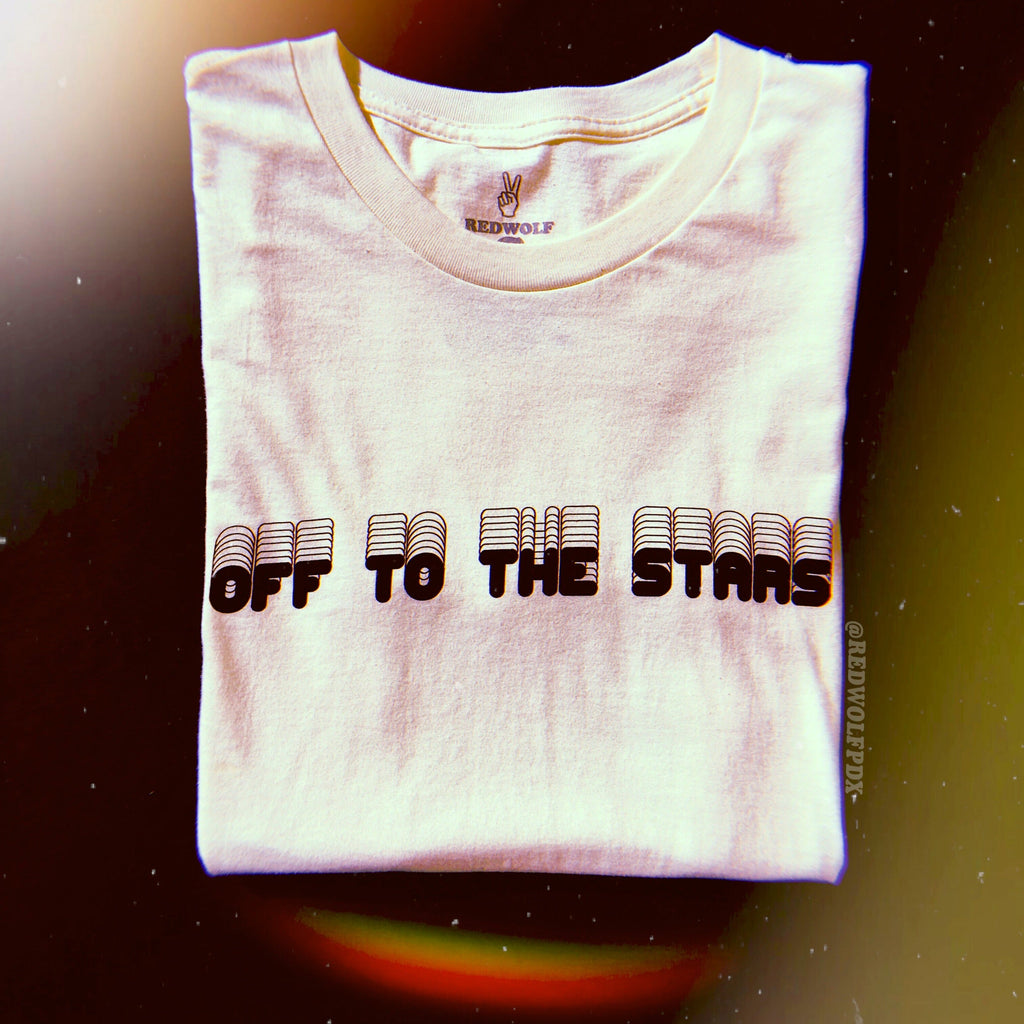 Folded white tee with text 'OFF TO THE STARS'  on chest against space background 